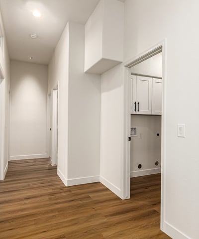 Bright hallway with updated flooring and neutral finishes connecting the living areas and bedrooms of this Scottsdale home. High ceilings and clean architectural lines enhance the spacious feel of the remodeled interior.