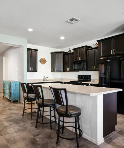 Functional kitchen with expansive island seating, dark cabinetry, and open sightlines to the living areas for effortless entertaining.