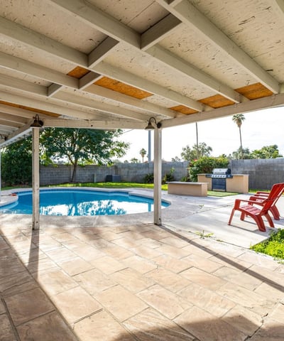 View from the patio doorway highlighting the private pool, covered patio, and outdoor entertaining space your own Phoenix backyard escape made for gatherings and relaxation.
