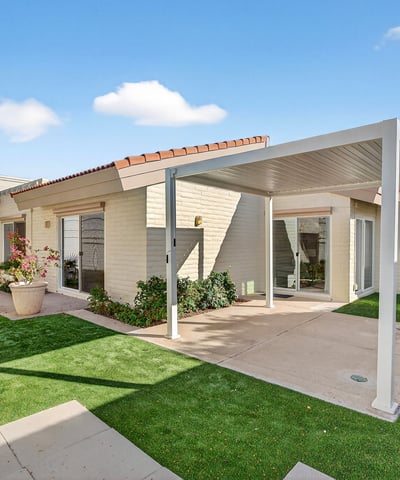 Private backyard with covered patio and turf landscaping, designed for easy care and outdoor enjoyment in Phoenix.