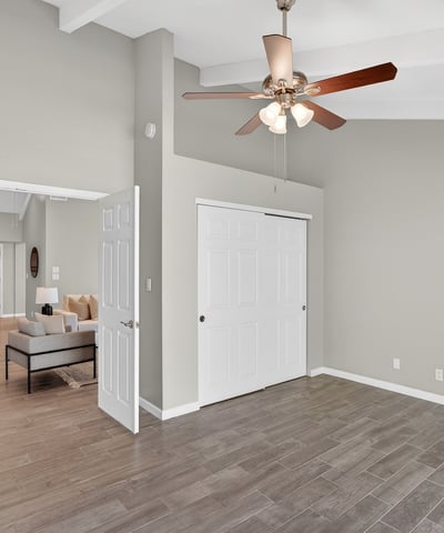 Guest bedroom with vaulted ceiling, neutral tones, and tile flooring, offering comfort and versatility for multiple living needs.