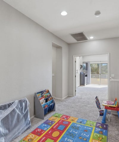 Open loft area overlooking the entryway, providing a flexible bonus space perfect for a playroom, second living room, study area, or media lounge in this Queen Creek home.