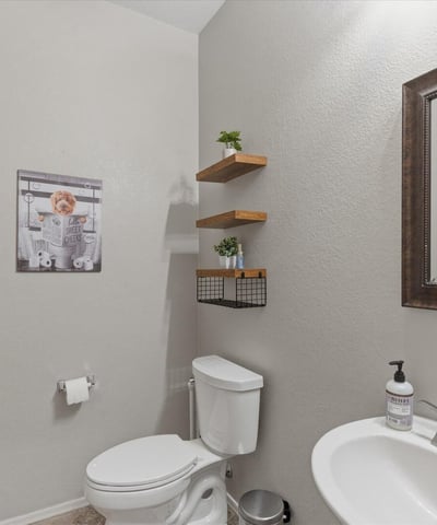 Convenient powder room with modern fixtures, pedestal sink, and neutral finishes ideal for guests visiting this Queen Creek home.