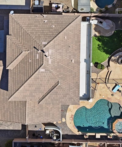 Direct overhead aerial showcasing the backyard design with pool, spa, patio seating areas, and landscaped yard perfect for outdoor entertaining in Queen Creek.
