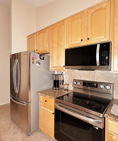 Cooking area with stainless steel range, built-in microwave, and tiled backsplash. This Phoenix home includes updated features and efficient layout.