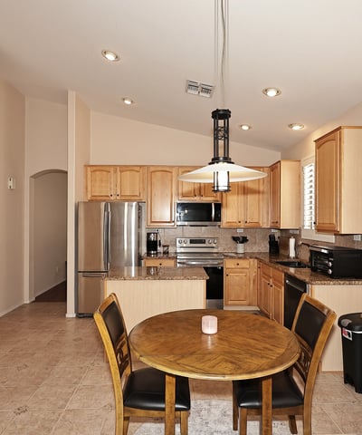 Open-concept kitchen and dining space with granite counters and plantation shutters. This Phoenix home is designed for easy entertaining and daily living.