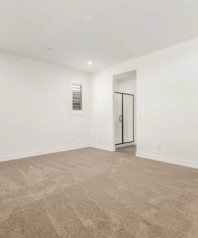 Generous primary suite with soft carpet, large windows, and peaceful ambiance. Designed for comfort and privacy.
