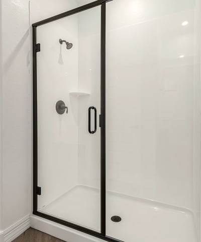 Walk-in shower with glass doors and contemporary fixtures, offering a clean and refreshed bathroom design.
