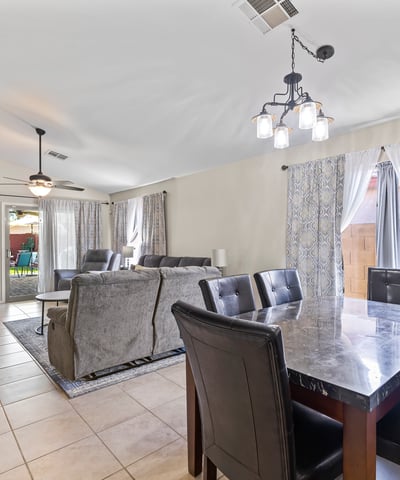 Flowing open layout connecting dining and living areas with tile flooring and natural light ideal for entertaining and daily comfort