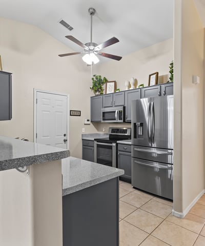 Open kitchen featuring breakfast bar, durable countertops, and included appliances ideal for casual meals and hosting.