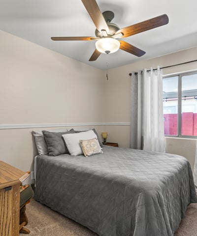 Cozy bedroom with carpet flooring, ceiling fan, and functional layout for everyday living.