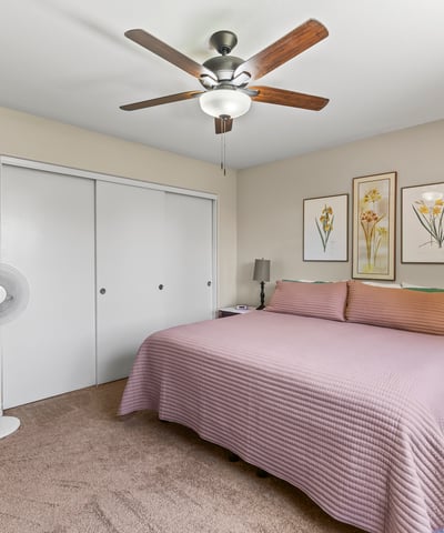 Comfortable primary bedroom with ceiling fan, plush carpet, and neutral finishes. A relaxing space designed for everyday living.