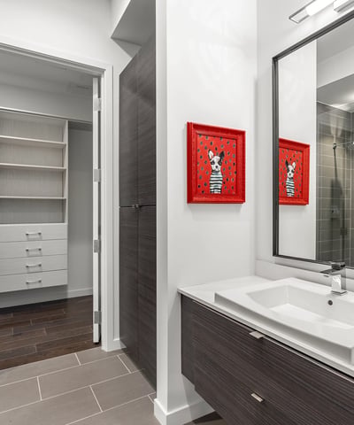 Well-designed bathroom with modern vanity, glass shower, and convenient access to a large closet, offering both style and practicality in Phoenix.