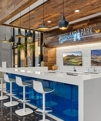 Modern lobby bar with clean lines, pendant lighting, and comfortable seating, offering a stylish gathering space in Phoenix.
