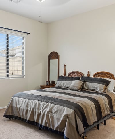 Inviting primary bedroom with large window, soft natural light, and neutral finishes, offering a peaceful retreat in this Phoenix home.