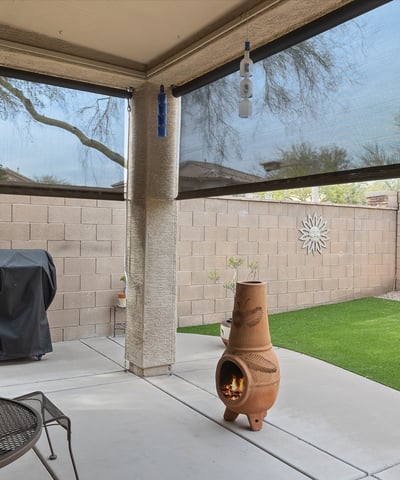 Backyard with artificial turf, covered patio, and low-maintenance design, ideal for outdoor relaxation and entertaining in Phoenix.