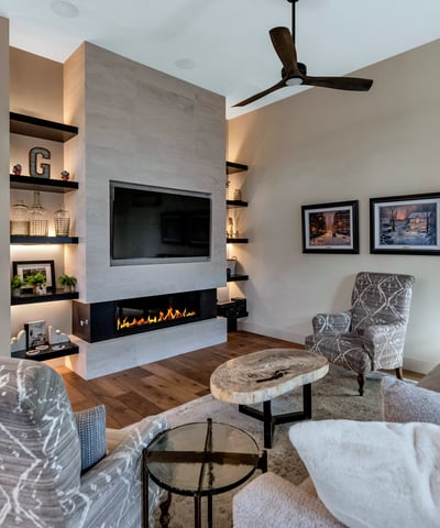 Contemporary fireplace wall with built-ins and warm finishes, adding both style and function to this Phoenix home s main living area.