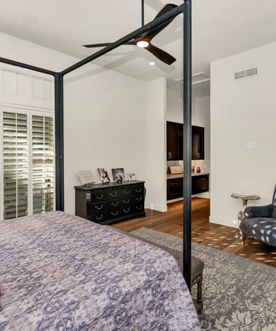 Inviting bedroom with ceiling fan, plantation shutters, and warm finishes, perfect for guests or additional living space in Phoenix.