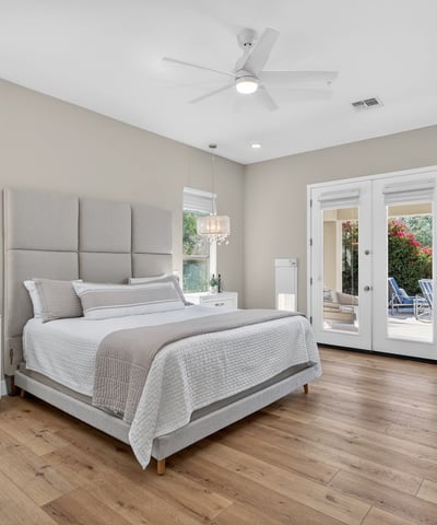 Beautiful Scottsdale primary suite with direct outdoor access, wood flooring, and modern ceiling fan, offering a peaceful and private retreat.
