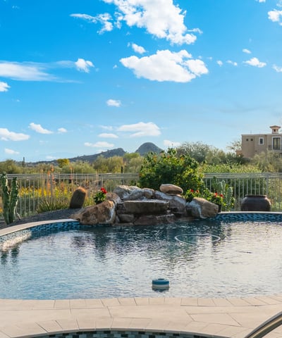 Scottsdale backyard with sparkling pool, water feature, and desert views, perfect for relaxing or entertaining outdoors.