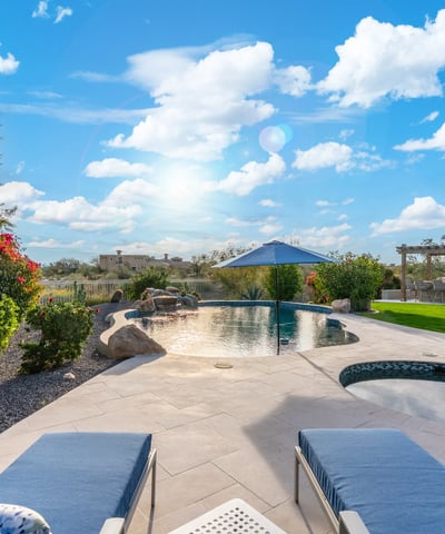 Scottsdale outdoor kitchen with pergola, built-in grill, and bar seating, creating a perfect space for entertaining guests.