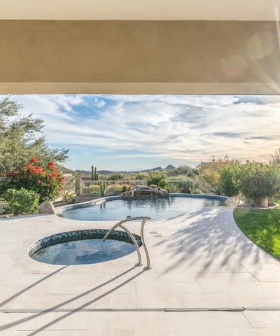 Scottsdale covered patio overlooking pool and spa with landscaped surroundings and mountain views, ideal for relaxing outdoors.