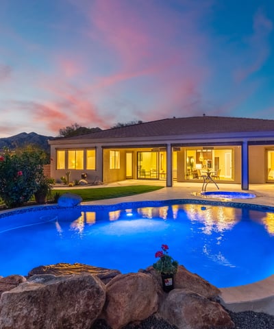 Scottsdale outdoor living at dusk with illuminated pool, spa, and patio, highlighting resort-style design and modern lighting.