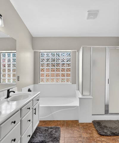 Bright primary bathroom with dual vanities, soaking tub, and walk-in shower. Functional layout offers everyday comfort in this Casa Grande property.