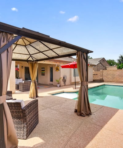 Backyard featuring a private pool and shaded pergola lounge area. Ideal for entertaining and enjoying warm Casa Grande evenings.
