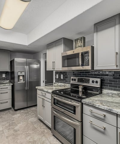 Kitchen featuring stainless steel appliances, updated cabinets, and stylish backsplash. This Sun City home showcases contemporary upgrades and efficient design.