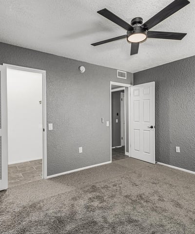 Spacious bedroom with neutral tones, ceiling fan, and convenient closet access. This Sun City home provides functional design and modern updates.