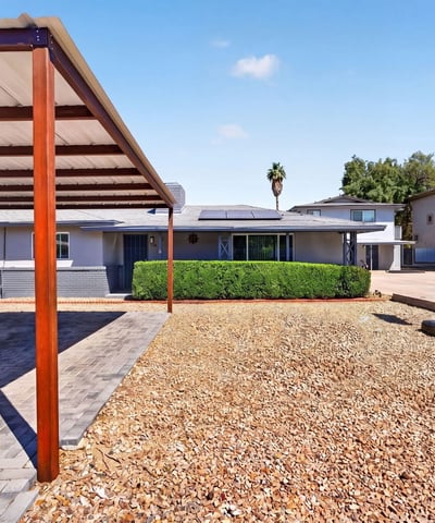 Clean front yard with gravel landscaping and covered parking, designed for durability and ease in this Phoenix multi-unit home.