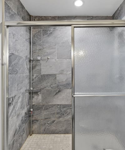 Contemporary walk-in shower with glass enclosure and upgraded tile, enhancing the home's modern appeal.