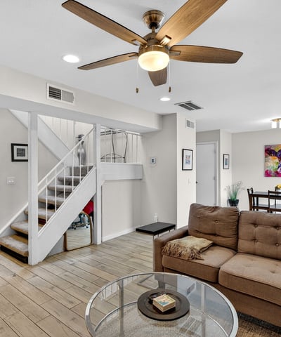 Spacious Scottsdale living area with tile flooring, ceiling fan, and open flow to dining and patio, perfect for comfortable everyday living.