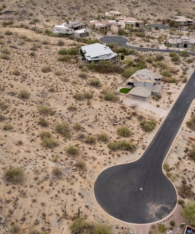 Expansive aerial view of this premium hillside lot surrounded by custom homes and breathtaking desert scenery. An ideal Phoenix location for building a luxury residence with mountain views.