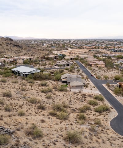 Exceptional aerial perspective showcasing the property s elevated setting among scenic desert terrain and luxury homes. Build your dream residence surrounded by breathtaking Phoenix mountain views.
