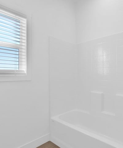 Bright full bathroom featuring a tub and shower combination, contemporary fixtures, and crisp finishes. Natural light and thoughtful design create a comfortable and welcoming space for residents and visitors.