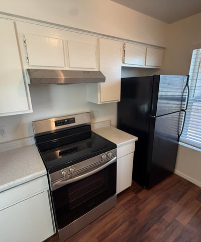 Kitchen highlights include updated black appliances, bright cabinetry, and easy-care countertops. The practical layout offers excellent workspace and storage for comfortable apartment living.