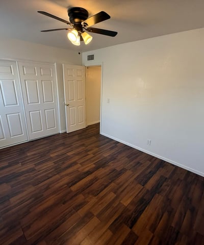Well-appointed bedroom with ceiling fan, ample closet storage, and attractive flooring throughout. This comfortable space offers privacy and flexibility for residents seeking functional living areas.