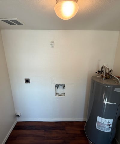 Interior utility room with washer and dryer hookups, dedicated laundry connections, and water heater access. This practical feature adds convenience and supports an efficient lifestyle.