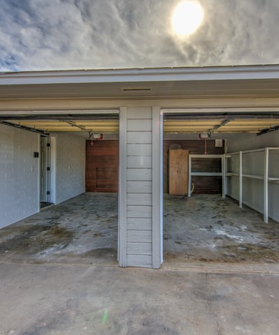 This roomy two-car garage features built-in shelving, ample storage, workspace potential, and convenient access, making it ideal for vehicles, projects, and organization.