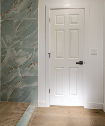 Enjoy a spa-like experience with a custom tiled walk-in shower, built-in bench, recessed niche, elegant vanity, and designer finishes throughout this beautifully remodeled bathroom.