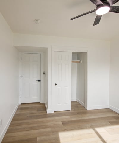A bright window, updated flooring, modern ceiling fan, and neutral finishes create a comfortable bedroom ready for immediate enjoyment.