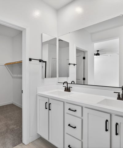 Enjoy added convenience with a spacious dual-sink vanity, modern cabinetry, quartz countertops, and direct access to the large walk-in closet in this thoughtfully designed ensuite.