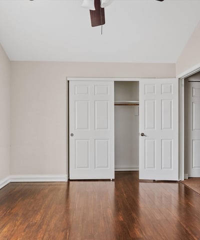 Wood flooring, ceiling fan, and a generously sized closet enhance this comfortable bedroom. The flexible layout works equally well for guests, family members, or a home office.