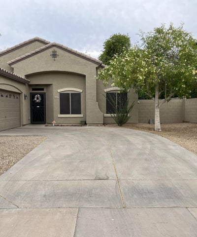 Angled view of the home's exterior highlighting the spacious driveway, RV gate, mature landscaping, and inviting architectural design that enhances this Canyon Trails property