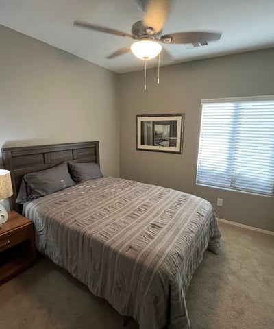 Bright secondary bedroom with neutral finishes, plush carpeting, ceiling fan, and closet space, providing flexibility for a guest room, nursery, or home office.