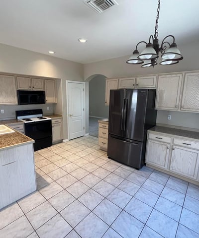 Designed for convenience, this spacious kitchen offers abundant cabinetry, extensive counter space, tile floors, pantry storage, and a bright dining area for casual meals.