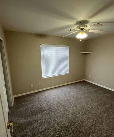 Bright and spacious, this secondary bedroom offers plush carpeting, natural light, a ceiling fan, and flexible space suitable for a variety of living needs.