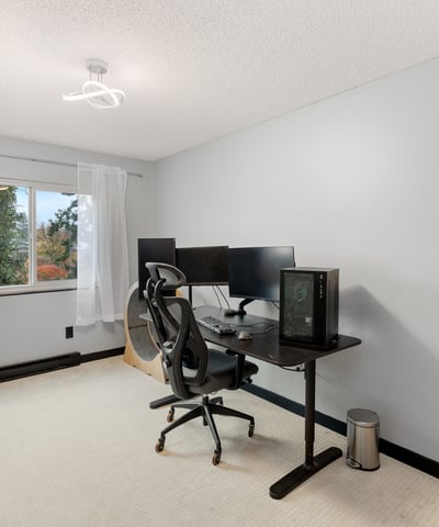 Bright and functional home office with dual monitors, natural light, and ample space for productivity.